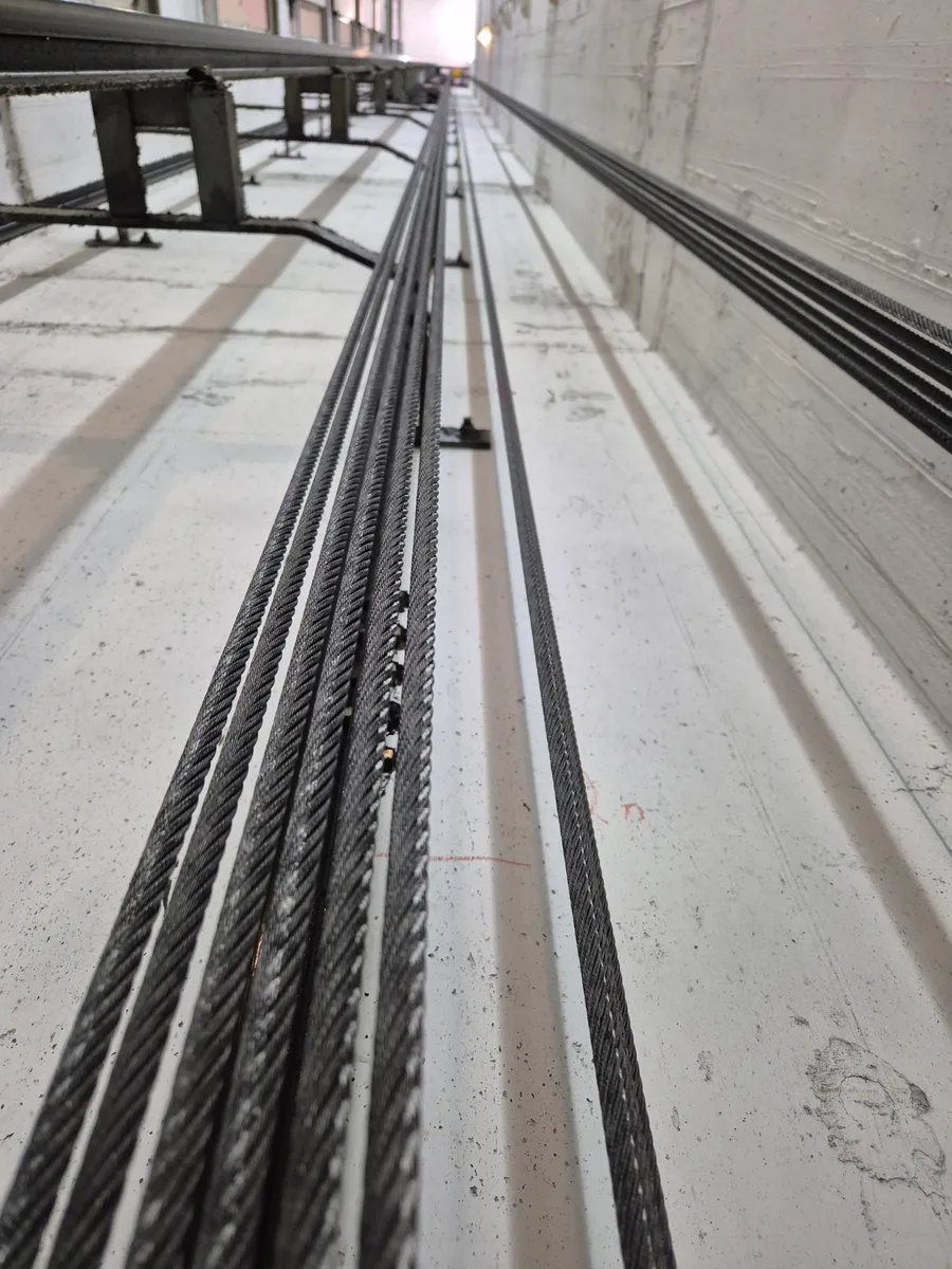 כבלי פלדה של מעלית לאורך הפיר, רכיב מכני שנשחק עם השנים